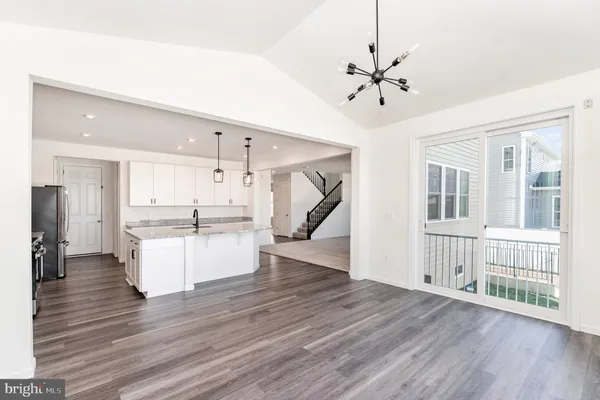 a large kitchen with stainless steel appliances kitchen island granite countertop a stove and a sink