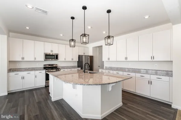 a kitchen with stainless steel appliances granite countertop a sink refrigerator and cabinets