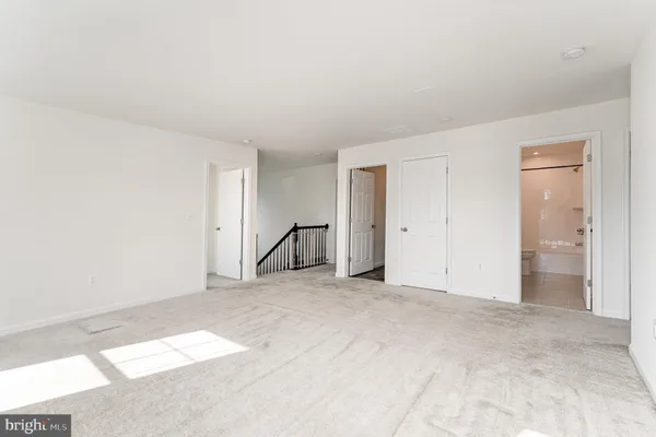 a view of an empty room with a window and bathroom