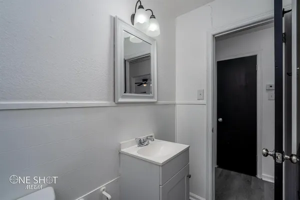 a bathroom with a sink a light fixture and a mirror