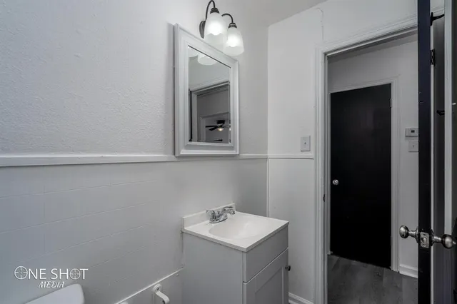 a bathroom with a sink a light fixture and a mirror