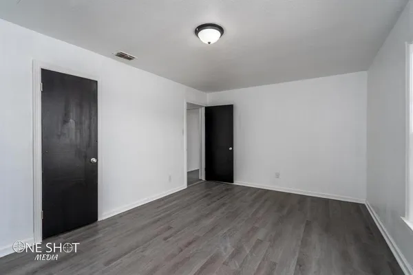 a view of an empty room with wooden floor