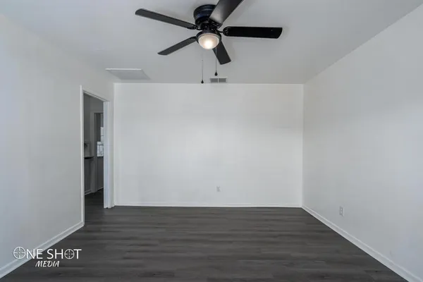 a view of an empty room with wooden floor