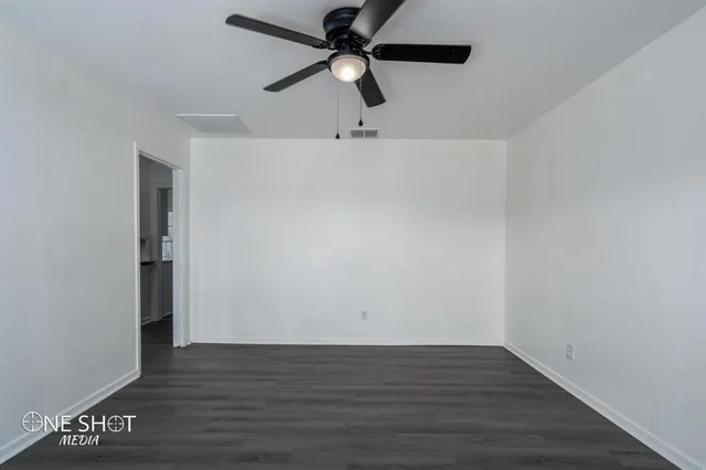 a view of an empty room with wooden floor