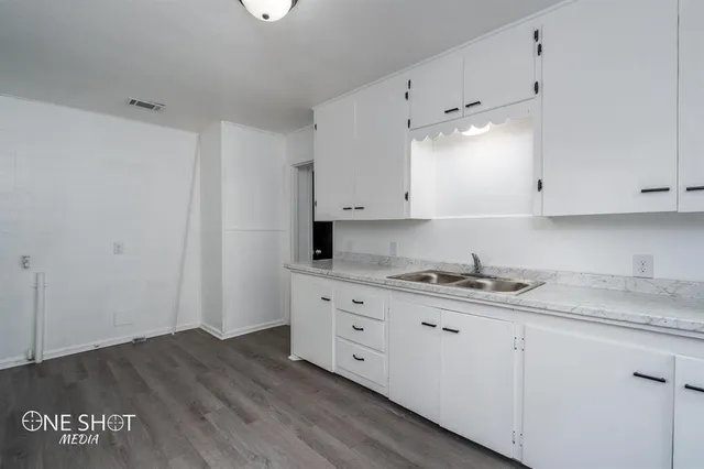 a kitchen with granite countertop white cabinets and white appliances
