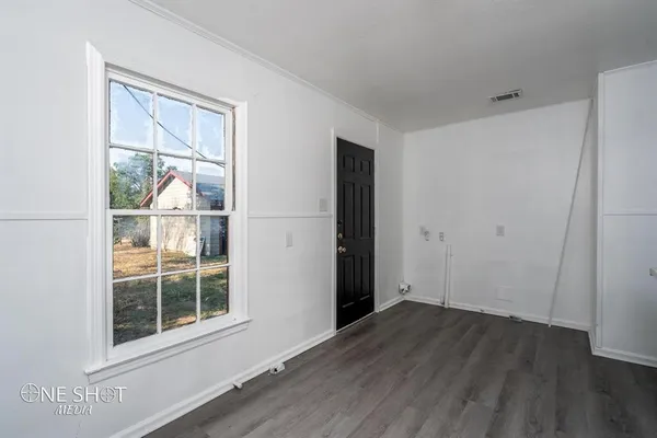 an empty room with wooden floor and a window