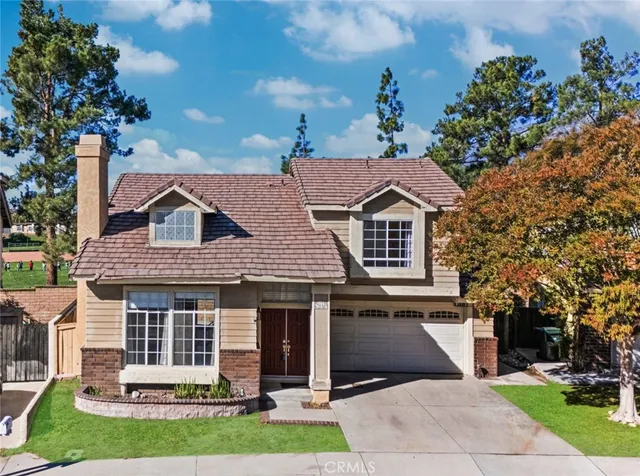 a front view of a house with a garden and trees