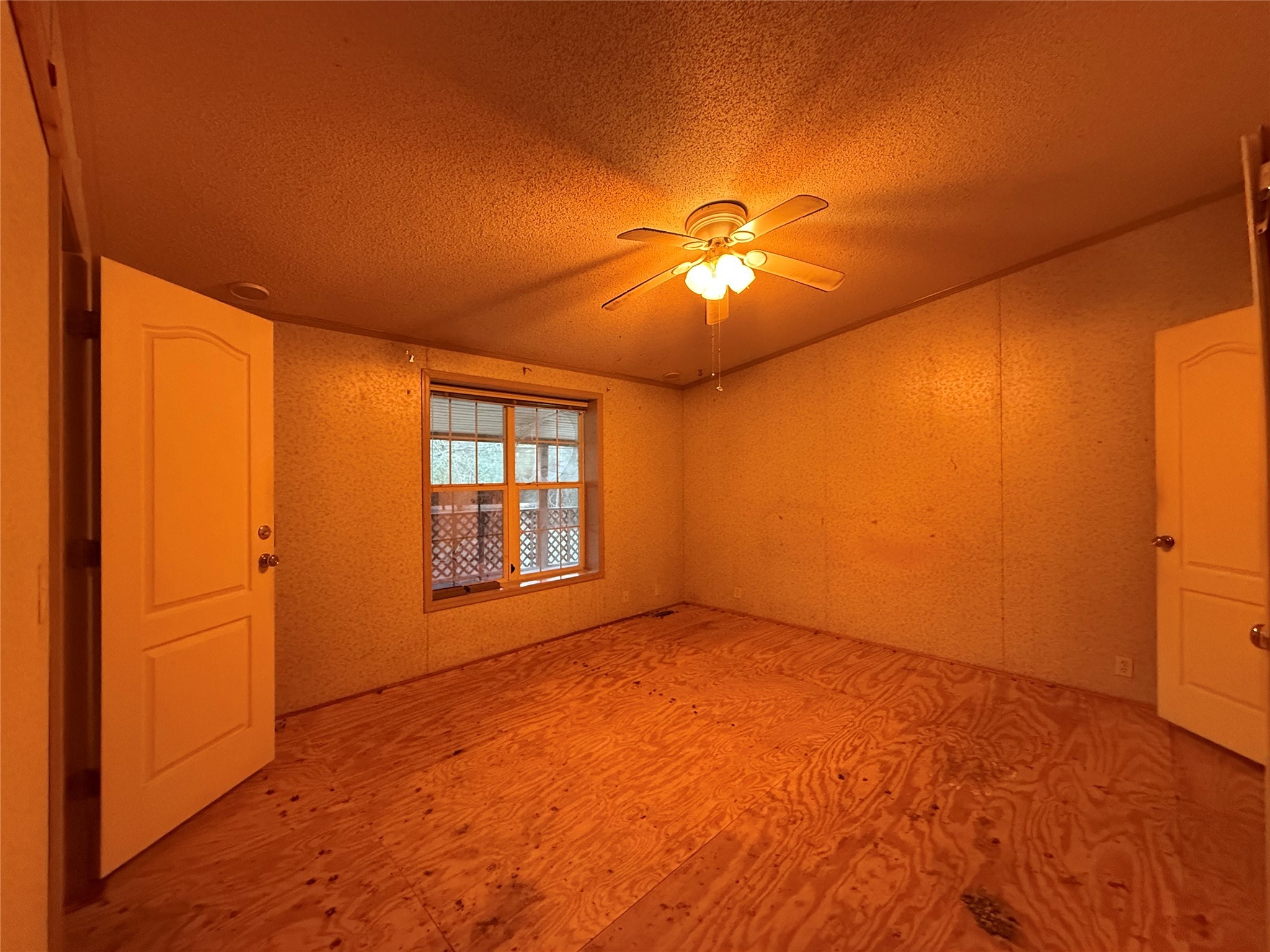 669 County Road 1245 Warren, TX 77664 - Photo 12 of 28 an empty room with a chandelier fan and windows