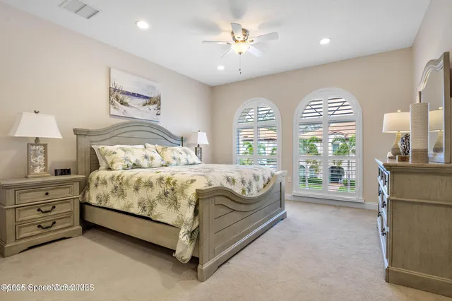 a bed sitting in a spacious bedroom next to a window