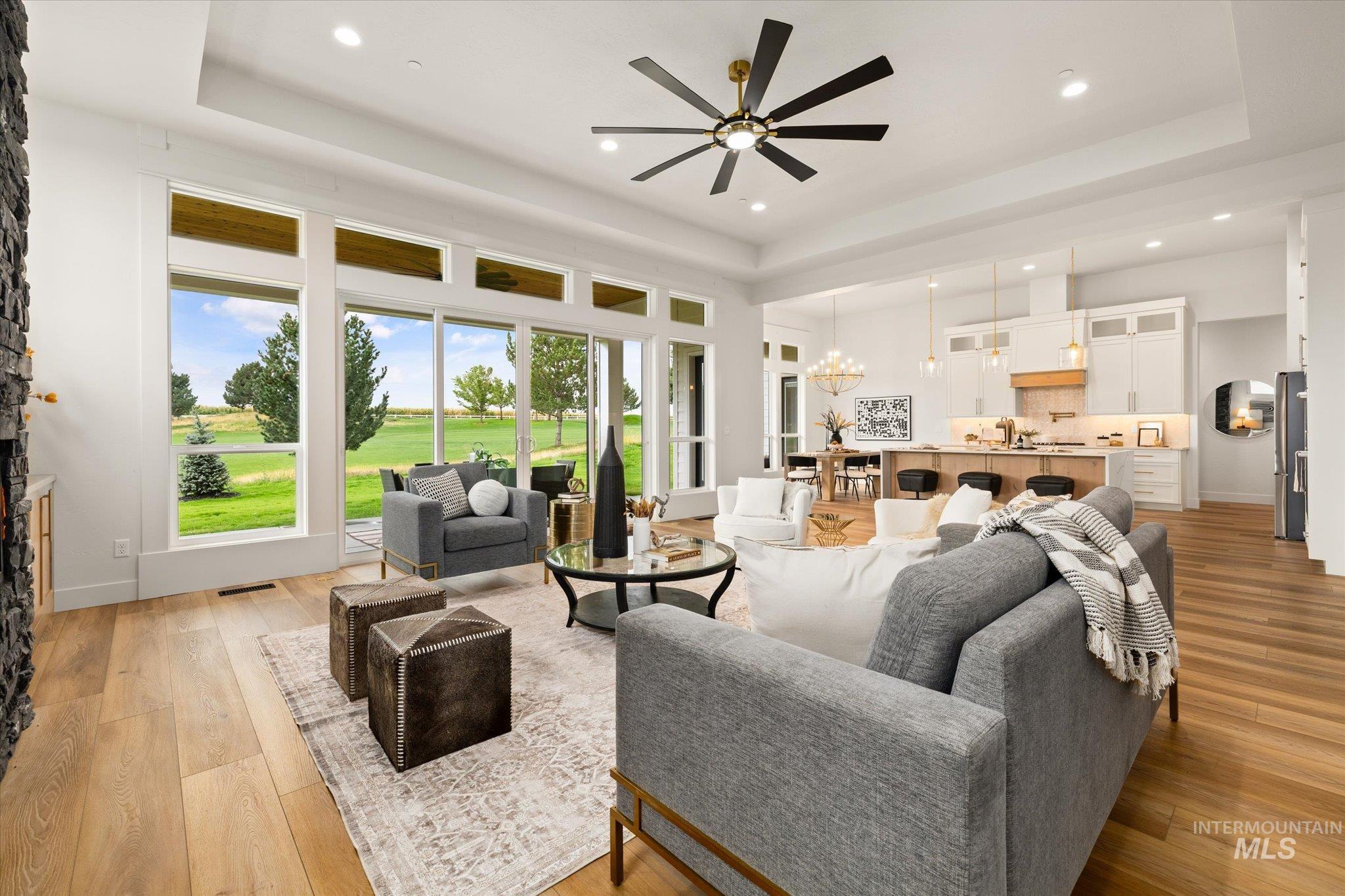 22909 Cirrus Vw Court Caldwell, ID 83607 - Photo 11 of 50 Living room with a raised ceiling, a chandelier, a ceiling fan, a fireplace, and recessed lighting