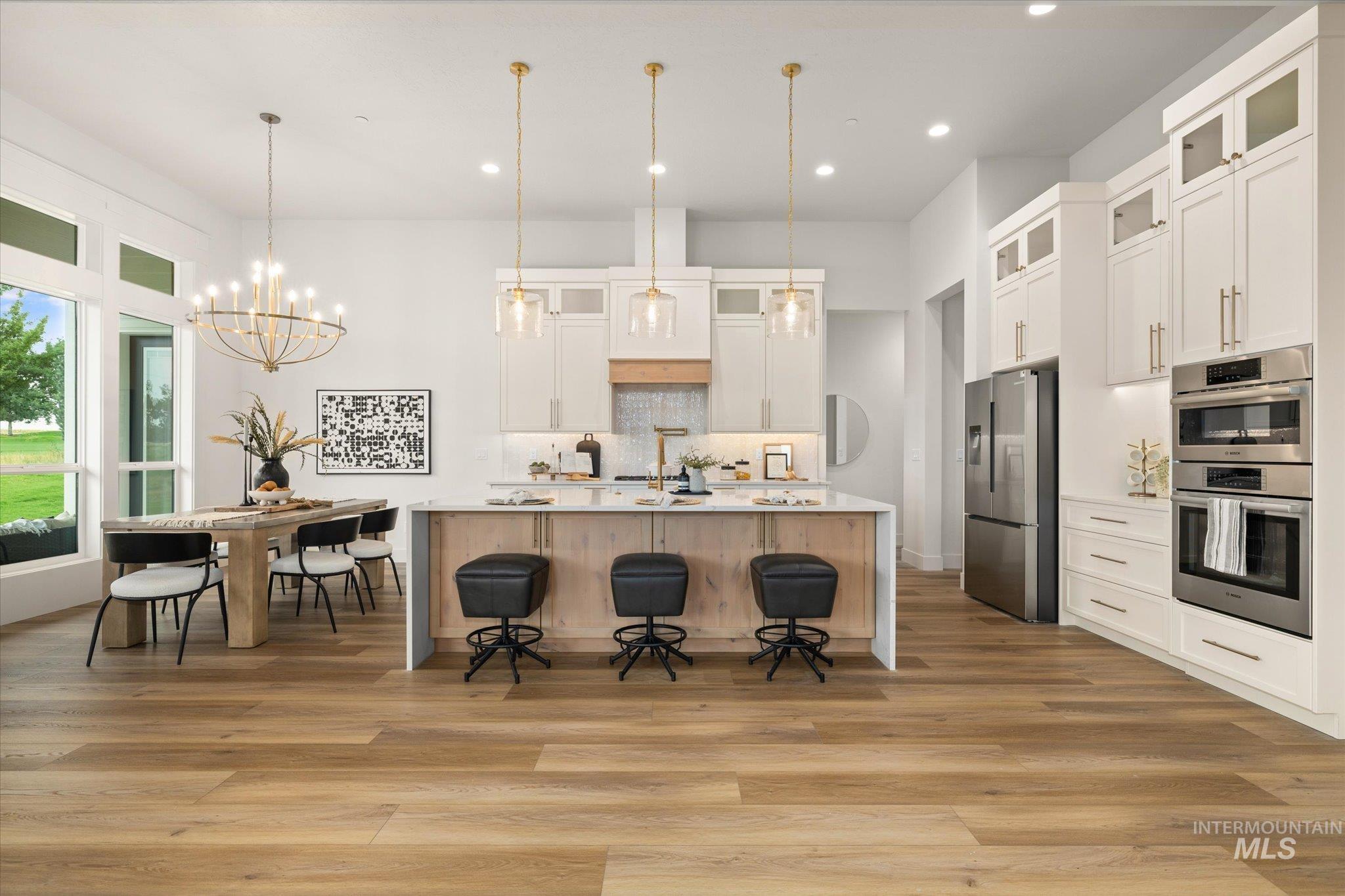 22909 Cirrus Vw Court Caldwell, ID 83607 - Photo 14 of 50 Kitchen with glass insert cabinets, tasteful backsplash, a breakfast bar area, a large island with sink, and recessed lighting