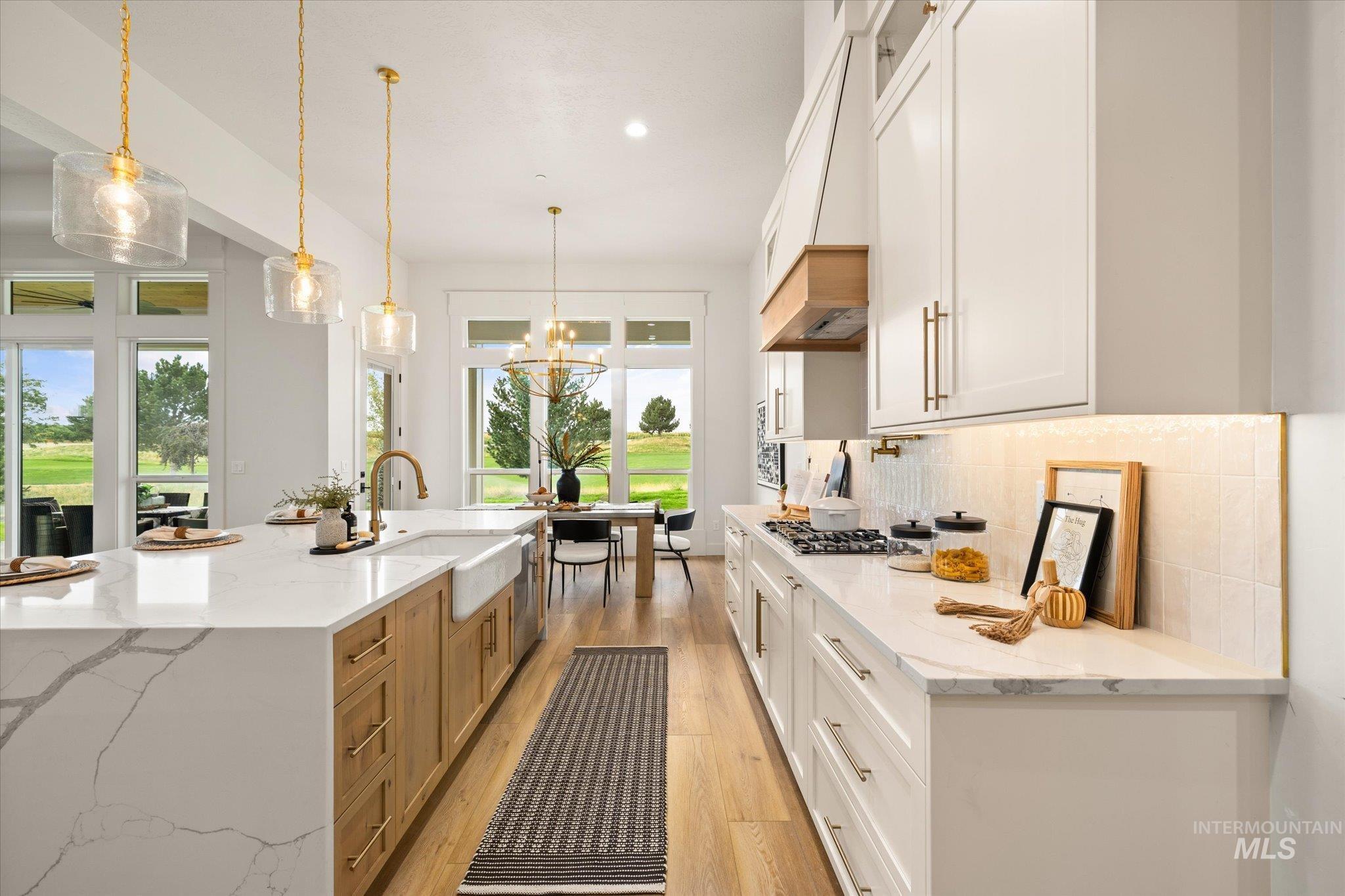 22909 Cirrus Vw Court Caldwell, ID 83607 - Photo 18 of 50 Kitchen with light stone countertops, white cabinets, hanging light fixtures, light wood-style floors, and recessed lighting