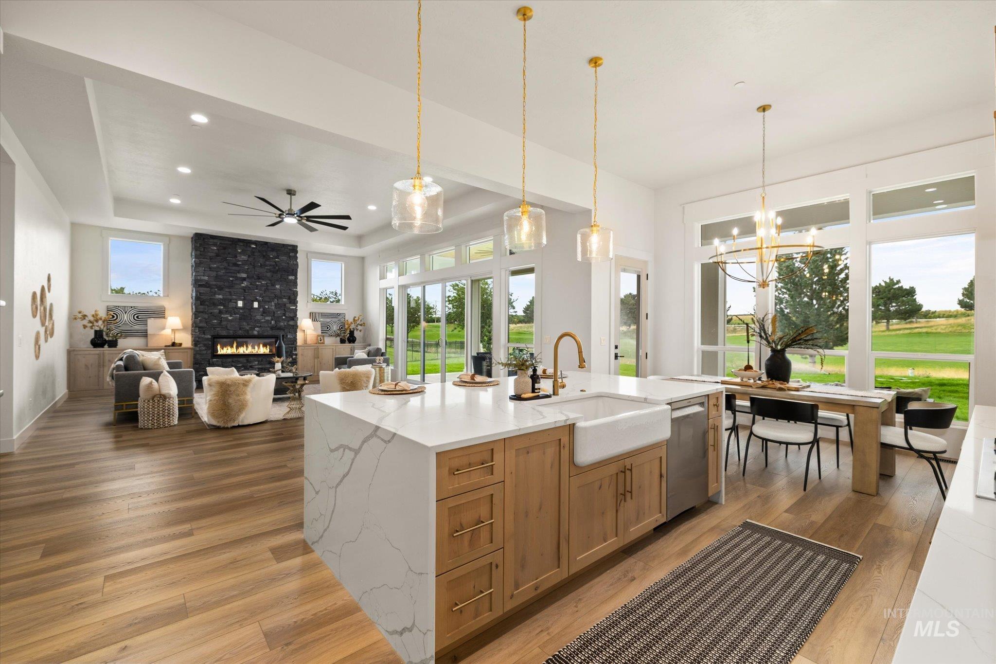 22909 Cirrus Vw Court Caldwell, ID 83607 - Photo 19 of 50 Kitchen with a raised ceiling, light stone counters, light wood-style floors, a fireplace, and decorative light fixtures