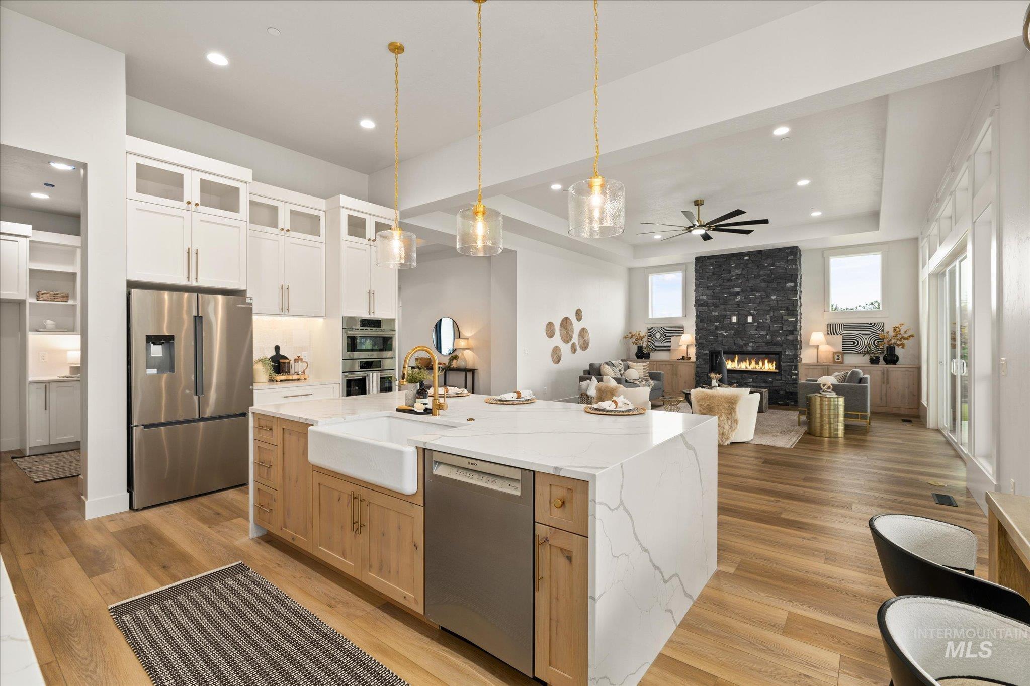 22909 Cirrus Vw Court Caldwell, ID 83607 - Photo 50 of 50 Kitchen with white cabinets, appliances with stainless steel finishes, glass insert cabinets, open floor plan, and light stone countertops