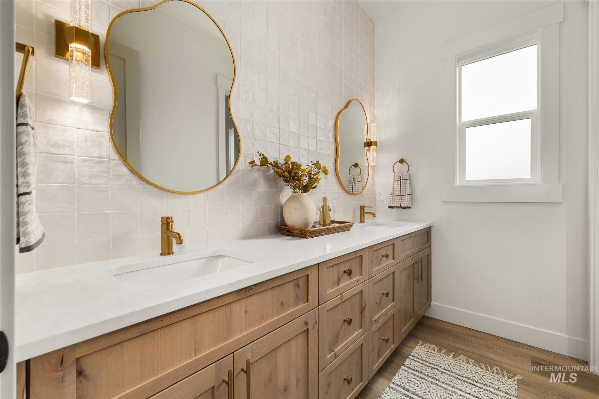 22909 Cirrus Vw Court Caldwell, ID 83607 - Photo 38 of 50 Bathroom with dark wood-style floors, double vanity, and tasteful backsplash
