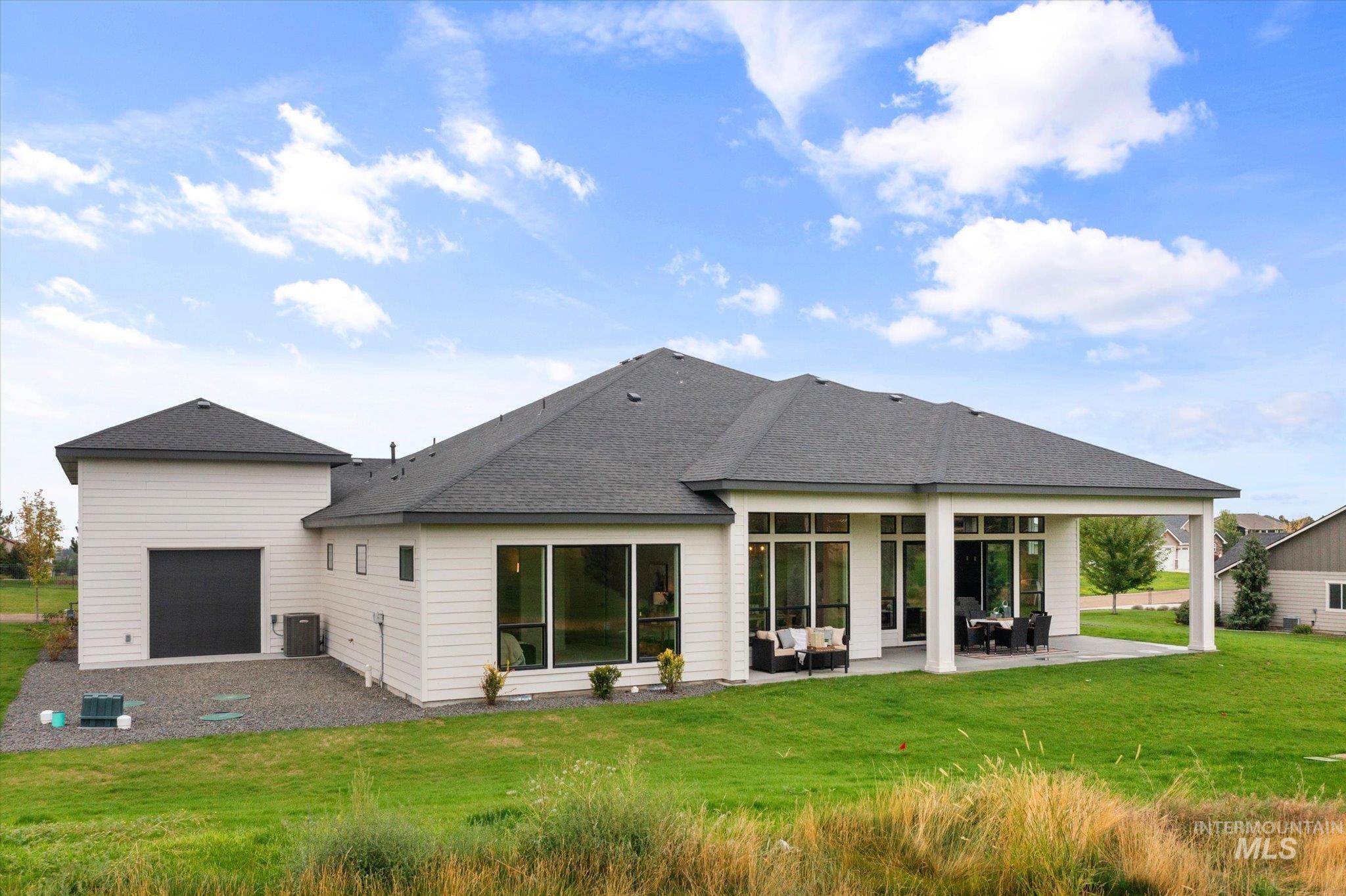 22909 Cirrus Vw Court Caldwell, ID 83607 - Photo 48 of 50 Back of property featuring a patio, a shingled roof, a yard, and an outdoor hangout area