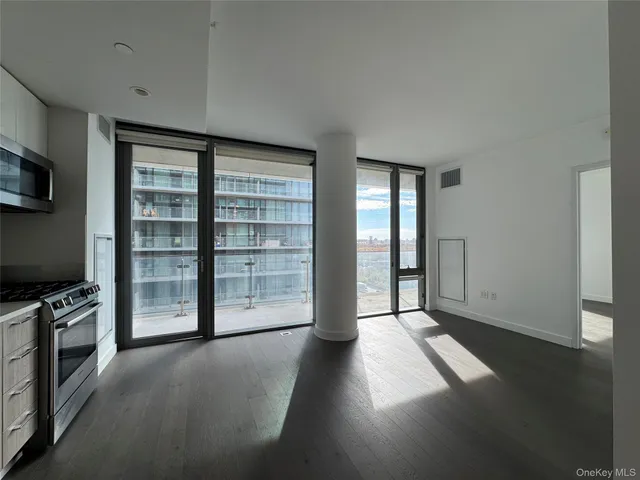 an empty room with windows and fireplace