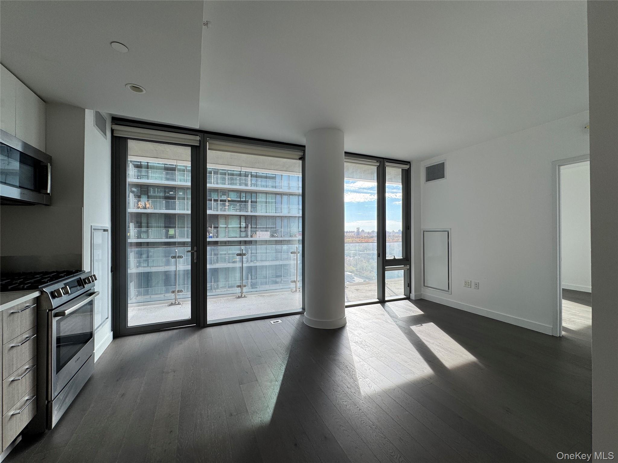 131-03 40 Road, Unit 16P Queens, NY 11354 - Photo 1 of 13 an empty room with windows and fireplace