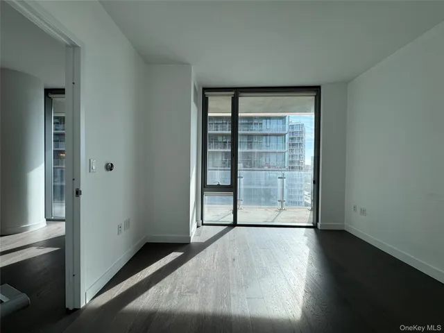 an empty room with wooden floor and cabinet
