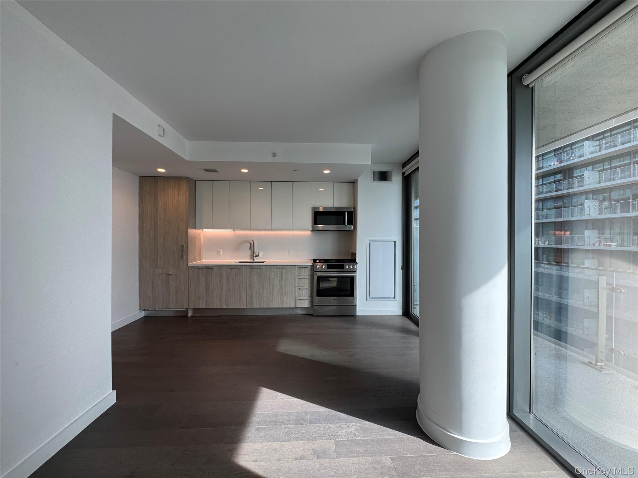 131-03 40 Road, Unit 16P Queens, NY 11354 - Photo 5 of 13 a view of a hallway with wooden floor and kitchen