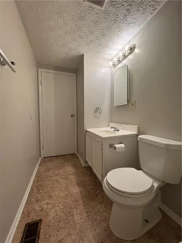 a bathroom with a toilet a sink a mirror and vanity