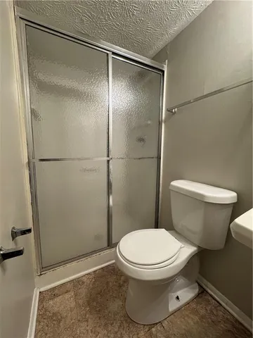 a white toilet sitting next to a shower