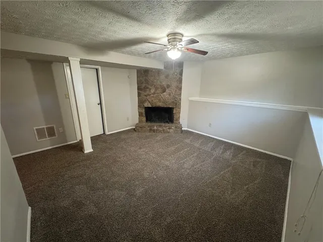 a view of an empty room with a chandelier fan
