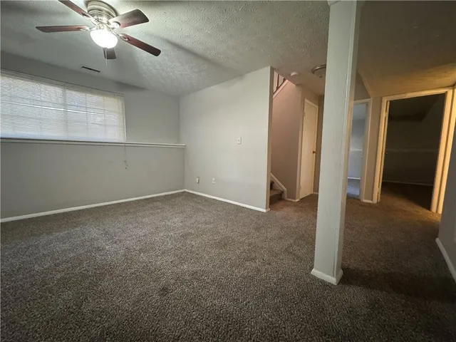 an empty room with closet and a chandelier fan