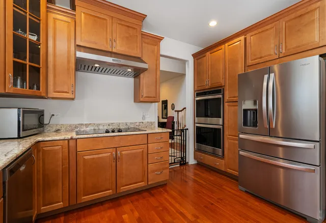 a kitchen with stainless steel appliances a refrigerator and a stove top oven