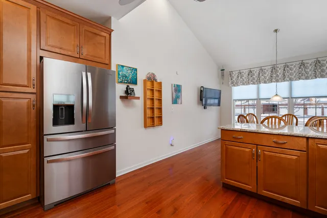 a kitchen with stainless steel appliances granite countertop a refrigerator a stove and a wooden floors