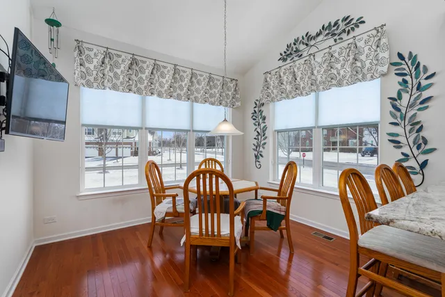 a dining room with furniture a chandelier and wooden floor