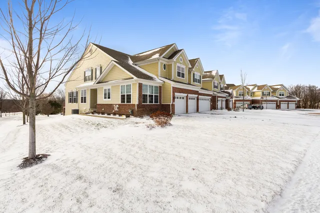 a view of a white house with a yard covered in snow