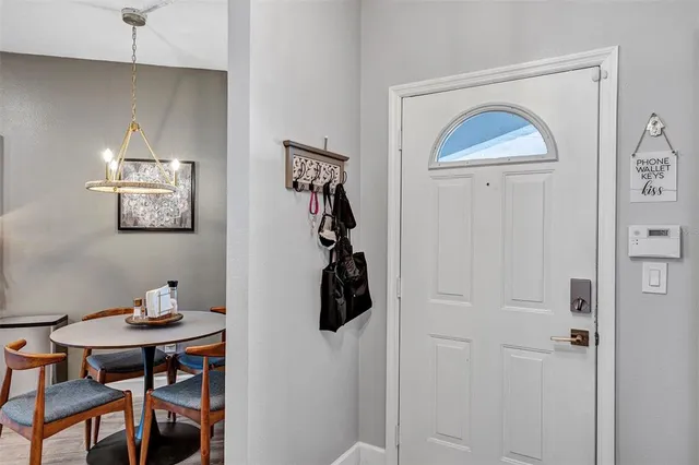 a view of a hallway with wooden floor and a bathroom