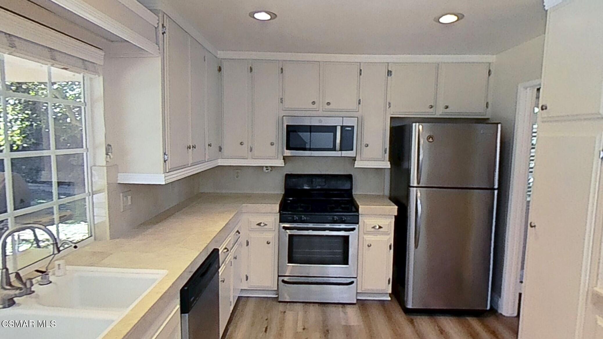 652 Harper Street Simi Valley, CA 93065 - Photo 12 of 30 a kitchen with white cabinets and white appliances