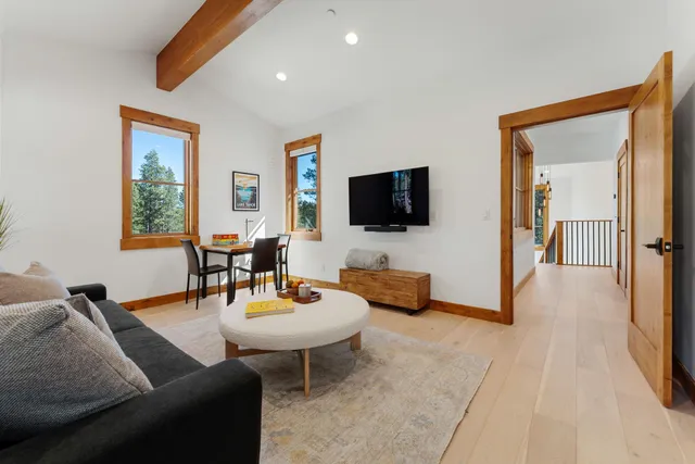 a living room with furniture a flat screen tv and a window