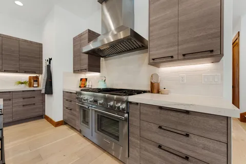 a kitchen with appliances wooden cabinets and a stove top oven