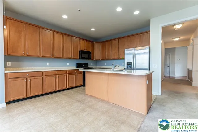 a kitchen with granite countertop a sink cabinets stainless steel appliances and a window