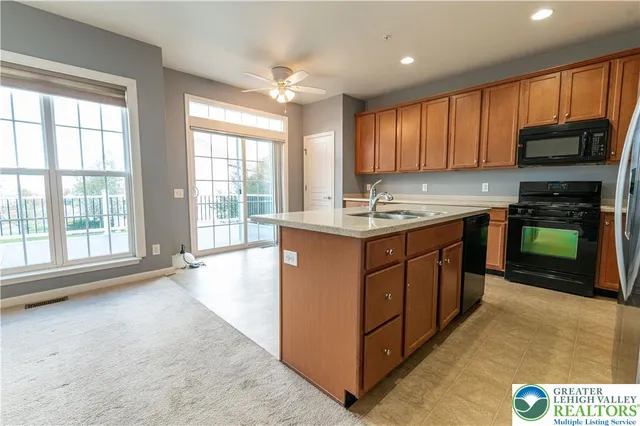 a kitchen with stainless steel appliances granite countertop a stove a sink and a microwave