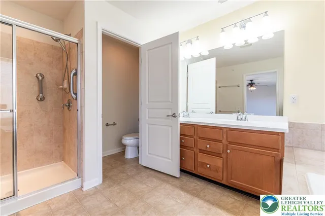 a bathroom with a granite countertop sink a toilet and shower
