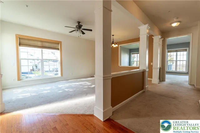 a view of a hallway with a window and wooden floor