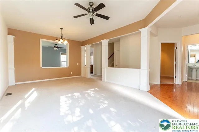 a view of a livingroom with a chandelier fan and wooden floor