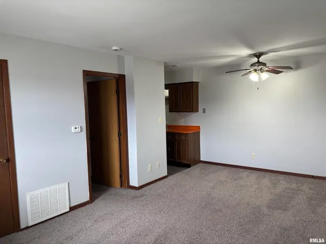 an empty room with windows cabinet and a flat screen tv