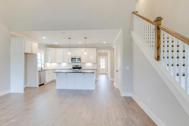 a large kitchen with cabinets wooden floor and stainless steel appliances