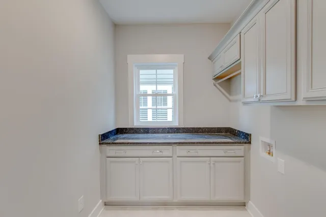 a kitchen with granite countertop white cabinets and a sink