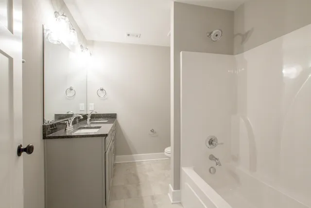 a bathroom with a granite countertop sink a mirror and a bathtub