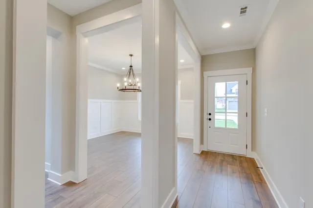 an empty room with wooden floor & windows