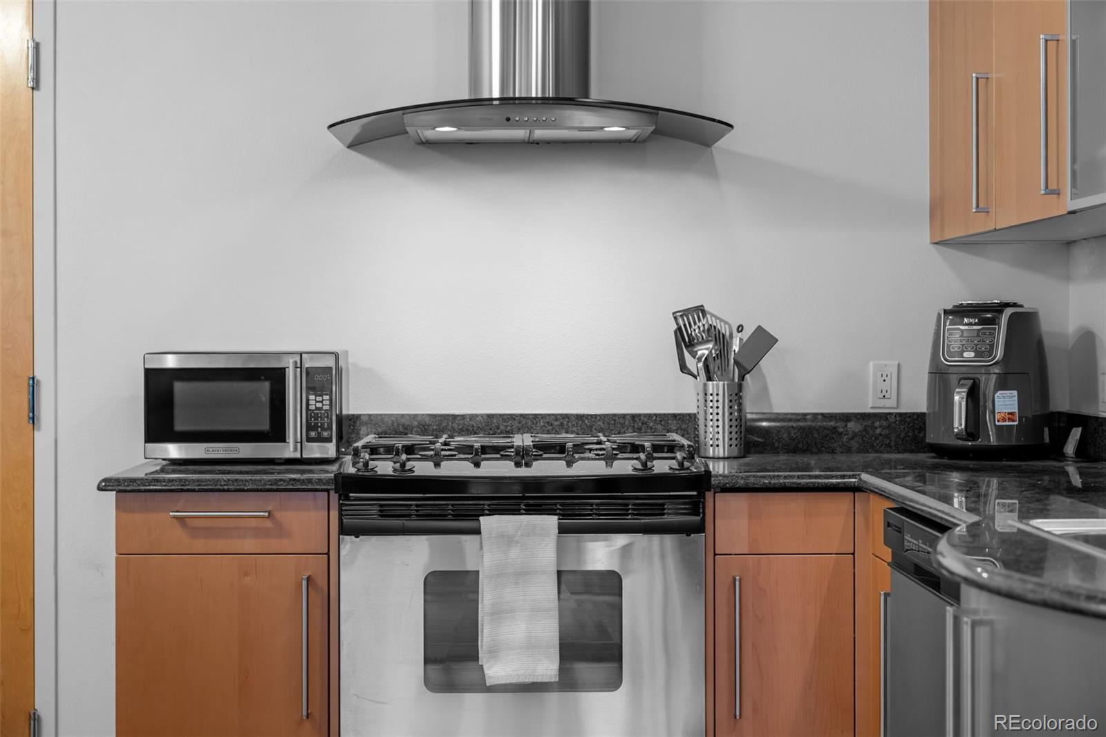 1401 Wewatta Street, Unit 311 Denver, CO 80202 - Photo 13 of 34 a kitchen with stainless steel appliances granite countertop a stove and a microwave