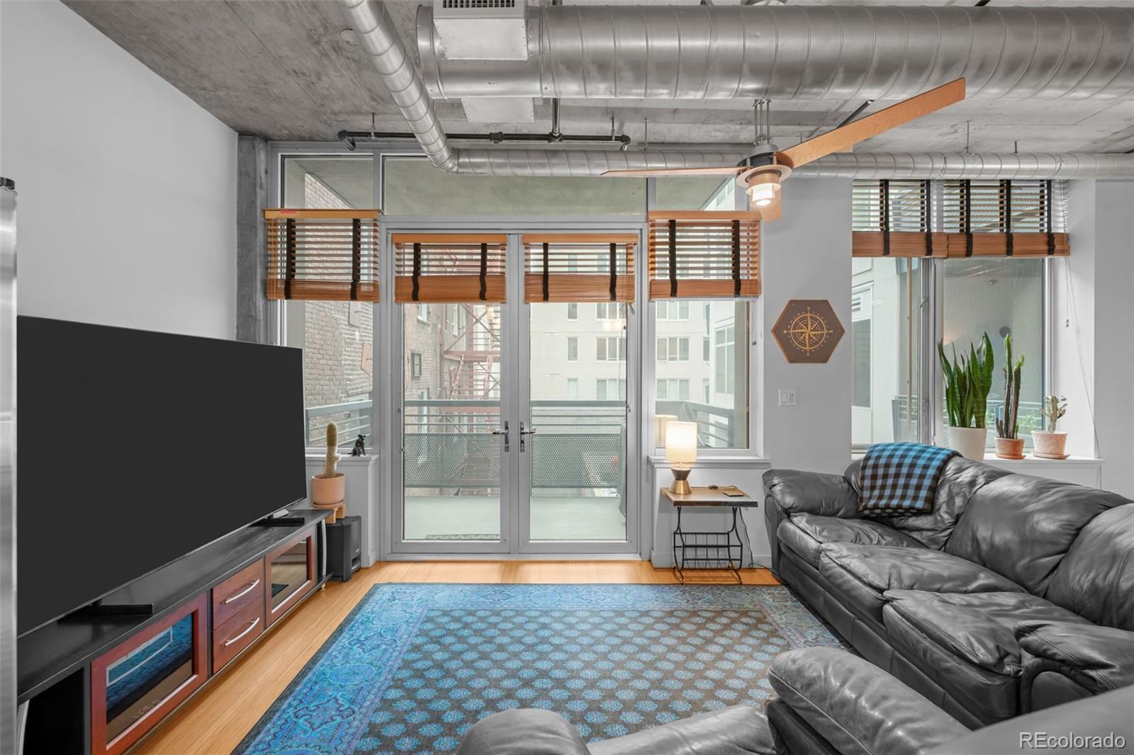 1401 Wewatta Street, Unit 311 Denver, CO 80202 - Photo 17 of 34 a living room with furniture and a flat screen tv