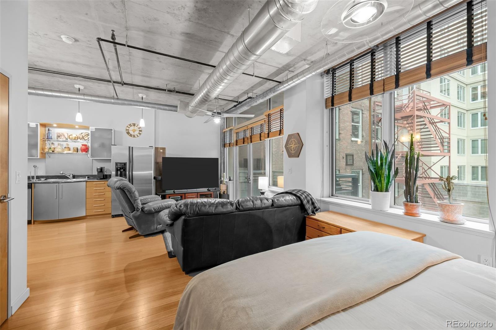 1401 Wewatta Street, Unit 311 Denver, CO 80202 - Photo 24 of 34 a living room with furniture a flat screen tv and a large window