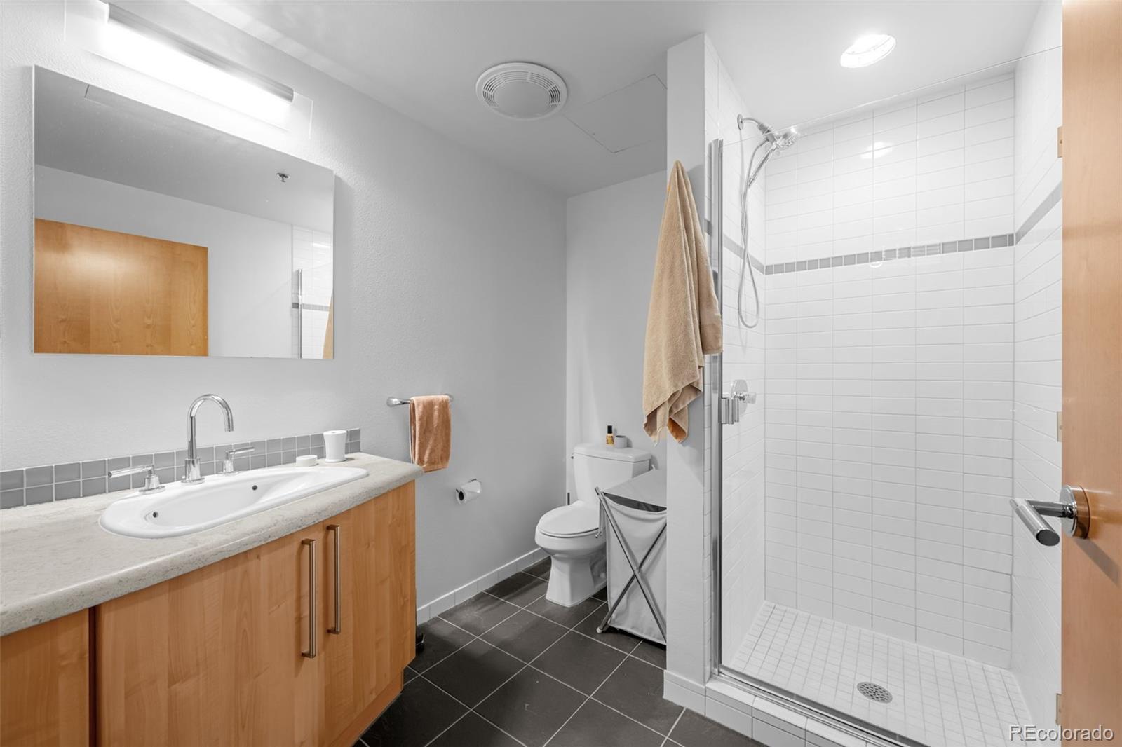 1401 Wewatta Street, Unit 311 Denver, CO 80202 - Photo 25 of 34 a bathroom with a double vanity sink mirror and toilet